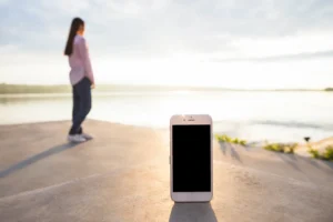 Imagen de un móvil solo en la playa con una persona de fondo mirando hacia otra parte